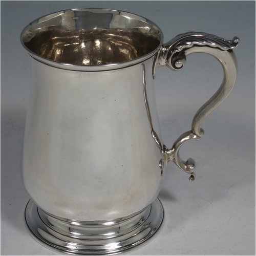 An Antique Georgian Sterling Silver pint tankard, having a plain round baluster body, a scroll handle, and sitting on a collet foot. Made by Fuller White of London in 1763. The dimensions of this fine hand-made antique silver tankard are height 12 cms (4.75 inches), diameter at top 8 cms (3 inches), and it weighs approx. 340g (11 troy ounces).   