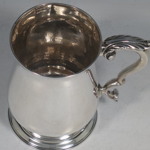 An Antique Georgian Sterling Silver pint tankard, having a plain round baluster body, a scroll handle, and sitting on a collet foot. Made by Fuller White of London in 1763. The dimensions of this fine hand-made antique silver tankard are height 12 cms (4.75 inches), diameter at top 8 cms (3 inches), and it weighs approx. 340g (11 troy ounces).   