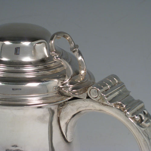 Antique Georgian sterling silver lidded quart tankard, having a plain bellied body, a hinged dome lid with thumb-piece, a scroll handle, sitting on a pedestal foot. Made by William Cripps of London in 1760. Weight approx. 758g (24.5 troy ounces). Please note that this piece has a small part-crest on the front of the body.