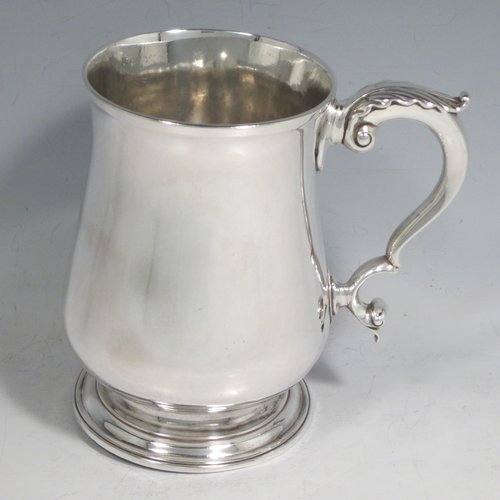 Antique Georgian sterling silver large and heavy mug / tankard, having a plain round baluster body, a scroll handle with anthemion leaf thumb-piece, and sitting on a collet foot. Made in London in 1771. The dimensions of this fine hand-made silver tankard / mug are height 13 cms (5 inches), diameter at top 8.5 cms (3.3 inches), and it weighs approx. 420g (13.5 troy ounces).   