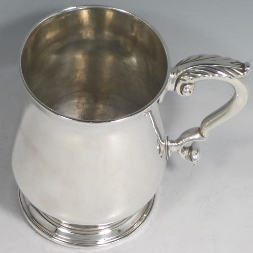 Antique Georgian sterling silver large and heavy mug / tankard, having a plain round baluster body, a scroll handle with anthemion leaf thumb-piece, and sitting on a collet foot. Made in London in 1771. The dimensions of this fine hand-made silver tankard / mug are height 13 cms (5 inches), diameter at top 8.5 cms (3.3 inches), and it weighs approx. 420g (13.5 troy ounces).   