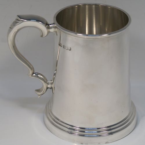 A very handsome Sterling Silver pint mug or tankard, in an early George I style, having a plain round straight-sided body with tapering sides, a scroll side-handle, and all sitting on a stepped collet foot. This elegant silver pint tankard or mug was made by Emile Viner of Sheffield in 1966. The dimensions of this fine hand-made silver tankard are height 12.5 cms (5 inches), diameter at top 8 cms (3.25 inches), and it weighs approx. 362g (11.7 troy ounces).   