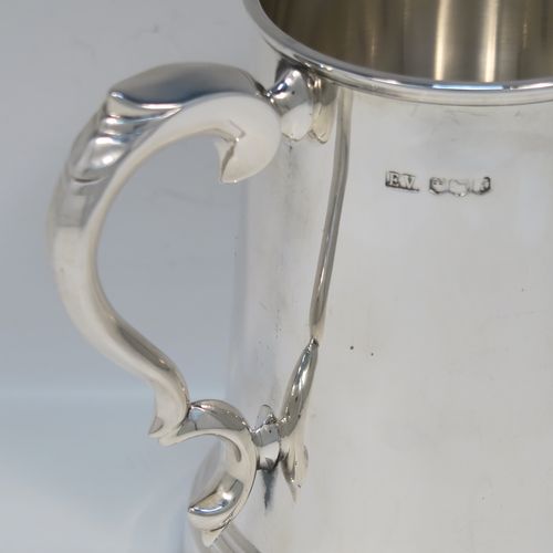 A very handsome Sterling Silver pint mug or tankard, in an early George I style, having a plain round straight-sided body with tapering sides, a scroll side-handle, and all sitting on a stepped collet foot. This elegant silver pint tankard or mug was made by Emile Viner of Sheffield in 1966. The dimensions of this fine hand-made silver tankard are height 12.5 cms (5 inches), diameter at top 8 cms (3.25 inches), and it weighs approx. 362g (11.7 troy ounces).   