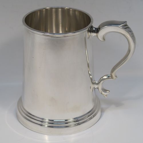 A very handsome Sterling Silver pint mug or tankard, in an early George I style, having a plain round straight-sided body with tapering sides, a scroll side-handle, and all sitting on a stepped collet foot. This elegant silver pint tankard or mug was made by Emile Viner of Sheffield in 1966. The dimensions of this fine hand-made silver tankard are height 12.5 cms (5 inches), diameter at top 8 cms (3.25 inches), and it weighs approx. 362g (11.7 troy ounces).   