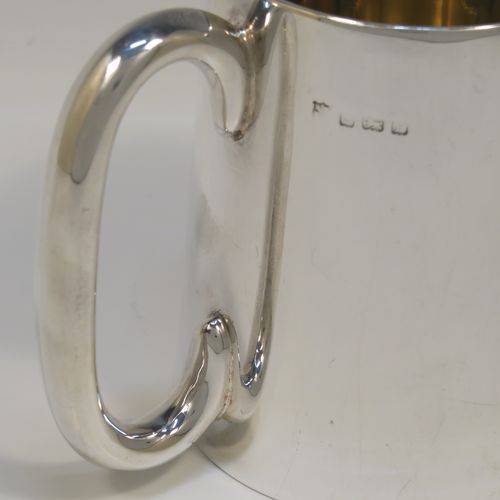 An elegant and heavy Sterling Silver pint mug or tankard having a plain round body with straight tapering sides, a plain loop side-handle, a gold-gilt interior, a hand-engraved spray of ivy and floral decoration on one side, and all sitting on a flat base. This beautiful silver tankard or mug was made by the Barker Brothers of Birmingham in 1930. The dimensions of this fine hand-made silver pint mug are height 11 cms (4.25 inches), diameter at top 8 cms (3 inches), and it weighs approx. 362g (11.7 troy ounces).   