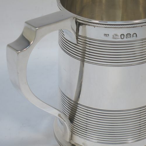 A very handsome Antique Georgian Sterling Silver pint tankard or mug, having a plain round straight-sided body with two bands of hand-chased reeded decoration and applied rope-twist top and bottom borders, a square cross-section scroll handle, and sitting on a flat base. Made by Solomon Royes of London in 1820. The dimensions of this fine hand-made antique silver mug or tankard are height 12 cms (4.75 inches), length 13 cms (5 inches), and it weighs approx. 324g (10.5 troy ounces).    