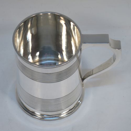 A very handsome Antique Georgian Sterling Silver pint tankard or mug, having a plain round straight-sided body with two bands of hand-chased reeded decoration and applied rope-twist top and bottom borders, a square cross-section scroll handle, and sitting on a flat base. Made by Solomon Royes of London in 1820. The dimensions of this fine hand-made antique silver mug or tankard are height 12 cms (4.75 inches), length 13 cms (5 inches), and it weighs approx. 324g (10.5 troy ounces).    