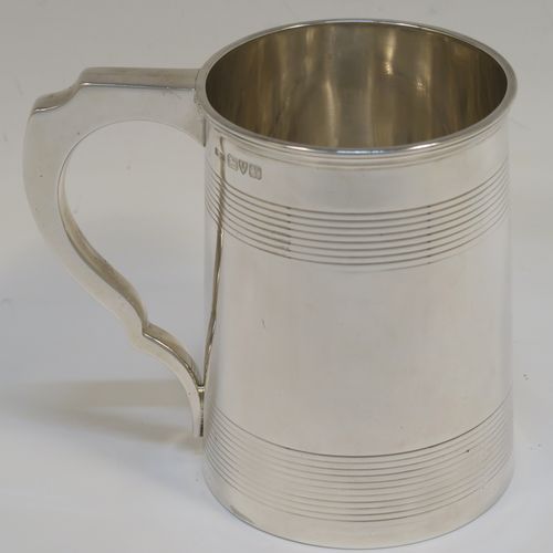 A very handsome Antique Sterling Silver pint tankard or mug, having a plain round straight-sided body with two bands of hand-chased reeded decoration, a square cross-section scroll handle, and sitting on a flat base. This elegant antique silver mug was made by Stokes and Ireland of Chester in 1921. The dimensions of this fine hand-made antique silver mug or tankard are height 11 cms (4.25 inches), length 12 cms (4.75 inches), and it weighs approx. 264g (8.5 troy ounces).   