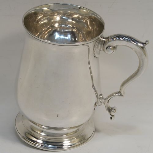 A very handsome Antique Georgian George III Sterling Silver pint tankard, having a plain round bellied body, a scroll handle with thumb-piece, and sitting on a pedestal foot. This elegant antique silver mug was made by Hester Bateman of London in 1786. The dimensions of this fine hand-made antique silver pint mug or tankard are height 12 cms (4.75 inches), diameter at top 8 cms (3 inches), and it weighs approx. 282g (9 troy ounces).   