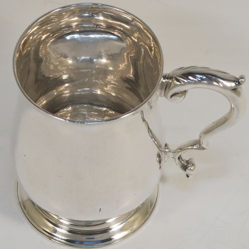 A very handsome Antique Georgian George III Sterling Silver pint tankard, having a plain round bellied body, a scroll handle with thumb-piece, and sitting on a pedestal foot. This elegant antique silver mug was made by Hester Bateman of London in 1786. The dimensions of this fine hand-made antique silver pint mug or tankard are height 12 cms (4.75 inches), diameter at top 8 cms (3 inches), and it weighs approx. 282g (9 troy ounces).   