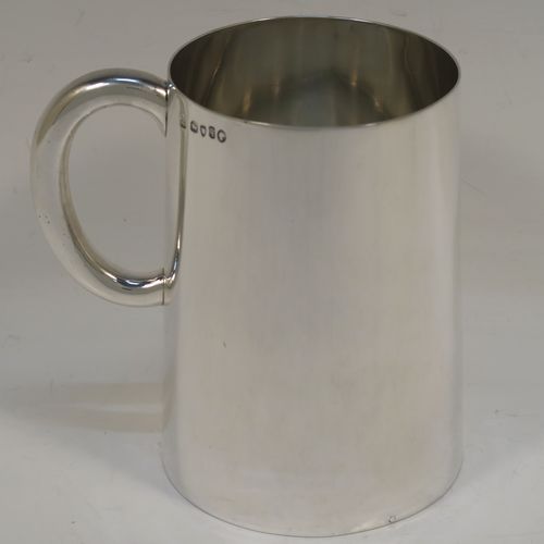 A rare and very handsome Antique Victorian Sterling Silver pint mug or tankard with a glass bottom, having a plain round body with straight tapering sides, a plain loop side-handle, and all sitting on a flat glass-bottomed base. This elegant silver tankard or mug was made by Andrew Crespel and Thomas Parker of London in 1871. The dimensions of this fine hand-made antique silver pint mug are height 12 cms (4.75 inches), and diameter at top 8 cms (3 inches).   