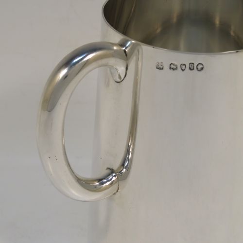 A rare and very handsome Antique Victorian Sterling Silver pint mug or tankard with a glass bottom, having a plain round body with straight tapering sides, a plain loop side-handle, and all sitting on a flat glass-bottomed base. This elegant silver tankard or mug was made by Andrew Crespel and Thomas Parker of London in 1871. The dimensions of this fine hand-made antique silver pint mug are height 12 cms (4.75 inches), and diameter at top 8 cms (3 inches).   