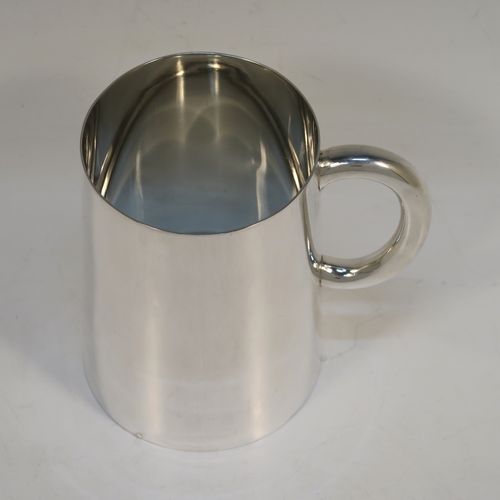 A rare and very handsome Antique Victorian Sterling Silver pint mug or tankard with a glass bottom, having a plain round body with straight tapering sides, a plain loop side-handle, and all sitting on a flat glass-bottomed base. This elegant silver tankard or mug was made by Andrew Crespel and Thomas Parker of London in 1871. The dimensions of this fine hand-made antique silver pint mug are height 12 cms (4.75 inches), and diameter at top 8 cms (3 inches).   