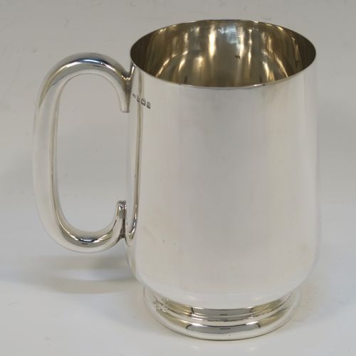 A very handsome Sterling Silver pint mug or tankard, having a plain round body with straight tapering sides and a tucked under belly, a plain loop side-handle, and all sitting on a pedestal foot. This elegant silver tankard or mug was made by Turner and Simpson of Birmingham in 1926. The dimensions of this fine hand-made silver pint mug are height 12 cms (4.75 inches), diameter at top 8 cms (3 inches), and it weighs approx. 288g (9.3 troy ounces).   