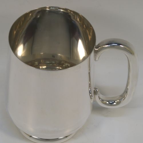 A very handsome Sterling Silver pint mug or tankard, having a plain round body with straight tapering sides and a tucked under belly, a plain loop side-handle, and all sitting on a pedestal foot. This elegant silver tankard or mug was made by Turner and Simpson of Birmingham in 1926. The dimensions of this fine hand-made silver pint mug are height 12 cms (4.75 inches), diameter at top 8 cms (3 inches), and it weighs approx. 288g (9.3 troy ounces).   