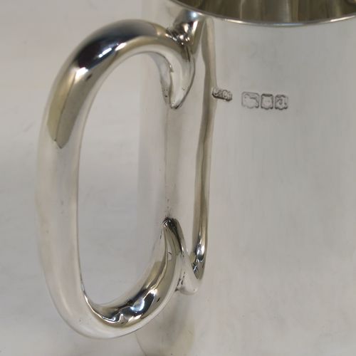 A very handsome Antique Sterling Silver pint mug or tankard, having a plain round body with straight tapering sides, a plain loop side-handle, and all sitting on a flat base. This elegant silver tankard or mug was made by Carrington and Co., of London in 1918. The dimensions of this fine hand-made antique silver pint mug are height 12 cms (4.75 inches), diameter at top 7.5 cms (3 inches), and it weighs approx. 281g (9 troy ounces).   