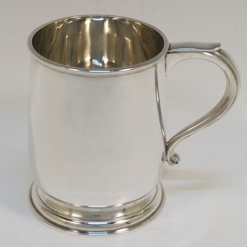 A heavy and very handsome Sterling Silver pint tankard or mug, having a plain round body with straight sides and a tucked under belly, a scroll side-handle, and sitting on a pedestal foot. This elegant silver pint mug was made by L. A. Crichton of London in 1934. The dimensions of this fine hand-made silver pint mug or tankard are height 12 cms (4.75 inches), diameter at top 9 cms (3.5 inches), and it weighs approx. 352g (11.3 troy ounces).   