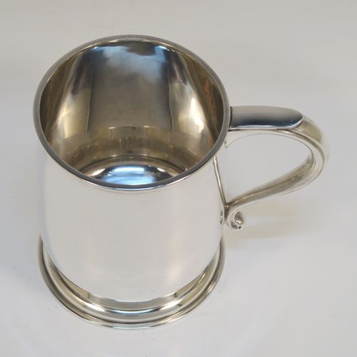 A heavy and very handsome Sterling Silver pint tankard or mug, having a plain round body with straight sides and a tucked under belly, a scroll side-handle, and sitting on a pedestal foot. This elegant silver pint mug was made by L. A. Crichton of London in 1934. The dimensions of this fine hand-made silver pint mug or tankard are height 12 cms (4.75 inches), diameter at top 9 cms (3.5 inches), and it weighs approx. 352g (11.3 troy ounces).   