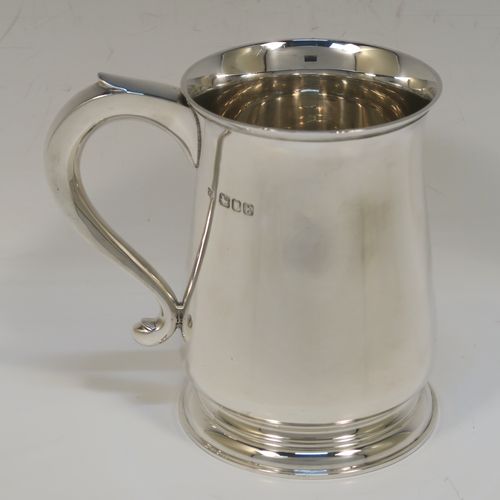 A handsome antique Sterling Silver pint tankard or mug, having a plain round body with straight sides and a tucked under belly, a plain scroll side-handle, and sitting on a pedestal foot. This elegant silver pint mug was made by Searle and Co. Ltd., of London in 1945. The dimensions of this fine hand-made antique silver pint mug or tankard are height 12.5 cms (5 inches), diameter at top 8.5 cms (3.3 inches), and it weighs approx. 360g (11.6 troy ounces).   