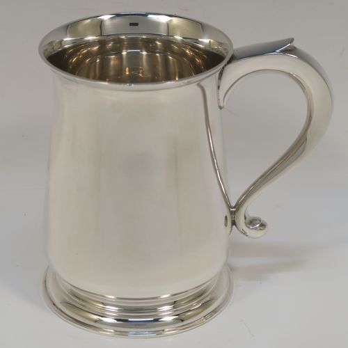 A handsome antique Sterling Silver pint tankard or mug, having a plain round body with straight sides and a tucked under belly, a plain scroll side-handle, and sitting on a pedestal foot. This elegant silver pint mug was made by Searle and Co. Ltd., of London in 1945. The dimensions of this fine hand-made antique silver pint mug or tankard are height 12.5 cms (5 inches), diameter at top 8.5 cms (3.3 inches), and it weighs approx. 360g (11.6 troy ounces).   