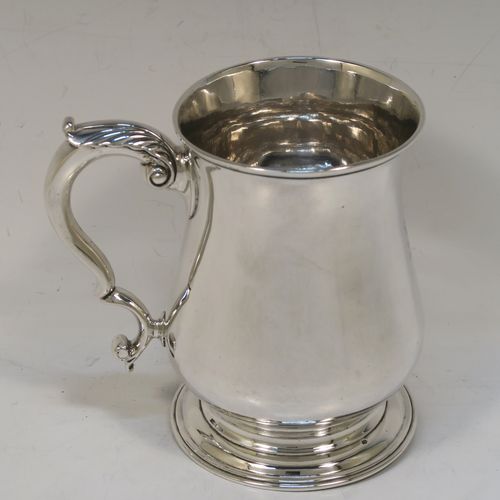 A very handsome and heavy Antique Georgian George II Sterling Silver pint tankard or mug, having a plain round bellied body, a scroll handle, and sitting on a pedestal foot. This elegant antique silver pint mug was made by William Shaw and William Priest of London in 1758. The dimensions of this fine hand-made antique silver pint mug or tankard are height 12.5 cms (5 inches), diameter at top 8.5 cms (3.3 inches), and it weighs approx. 379g (12.2 troy ounces).  