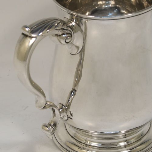 A very handsome and heavy Antique Georgian George II Sterling Silver pint tankard or mug, having a plain round bellied body, a scroll handle, and sitting on a pedestal foot. This elegant antique silver pint mug was made by William Shaw and William Priest of London in 1758. The dimensions of this fine hand-made antique silver pint mug or tankard are height 12.5 cms (5 inches), diameter at top 8.5 cms (3.3 inches), and it weighs approx. 379g (12.2 troy ounces).  