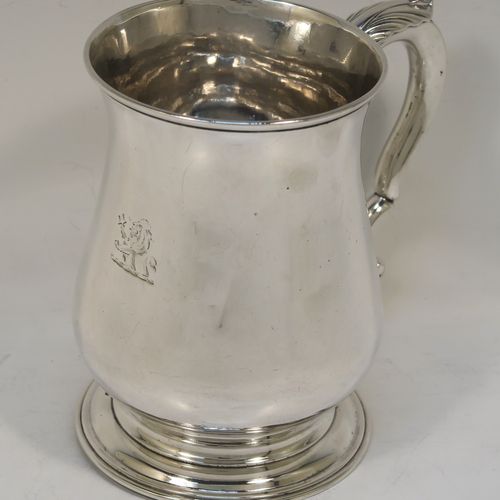 A very handsome and heavy Antique Georgian George II Sterling Silver pint tankard or mug, having a plain round bellied body, a scroll handle, and sitting on a pedestal foot. This elegant antique silver pint mug was made by William Shaw and William Priest of London in 1758. The dimensions of this fine hand-made antique silver pint mug or tankard are height 12.5 cms (5 inches), diameter at top 8.5 cms (3.3 inches), and it weighs approx. 379g (12.2 troy ounces).  