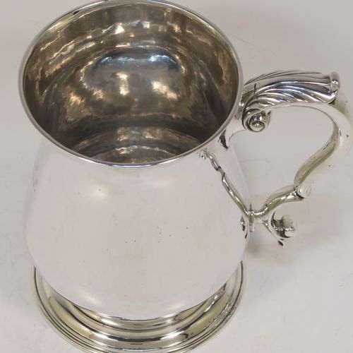 A very handsome and heavy Antique Georgian George II Sterling Silver pint tankard or mug, having a plain round bellied body, a scroll handle, and sitting on a pedestal foot. This elegant antique silver pint mug was made by William Shaw and William Priest of London in 1758. The dimensions of this fine hand-made antique silver pint mug or tankard are height 12.5 cms (5 inches), diameter at top 8.5 cms (3.3 inches), and it weighs approx. 379g (12.2 troy ounces).  