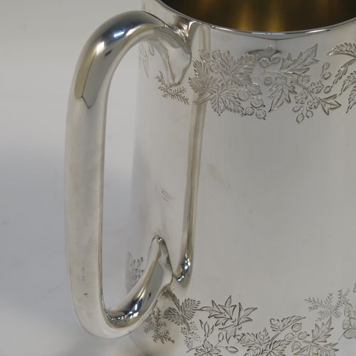 A very pretty Antique Victorian Sterling Silver pint mug or tankard, having a round body with straight tapering sides, with two bands of hand-engraved floral decoration, a gold-gilt interior, and a plain loop side-handle. This beautiful silver tankard or mug was made in Sheffield in 1878. The dimensions of this fine hand-made antique silver pint mug are height 13 cms (5 inches), diameter at top 7.5 cms (3 inches), and it weighs approx. 297g (9.6 troy ounces).   