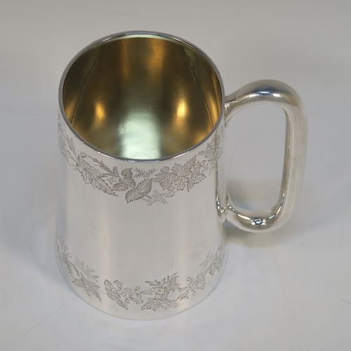 A very pretty Antique Victorian Sterling Silver pint mug or tankard, having a round body with straight tapering sides, with two bands of hand-engraved floral decoration, a gold-gilt interior, and a plain loop side-handle. This beautiful silver tankard or mug was made in Sheffield in 1878. The dimensions of this fine hand-made antique silver pint mug are height 13 cms (5 inches), diameter at top 7.5 cms (3 inches), and it weighs approx. 297g (9.6 troy ounces).   