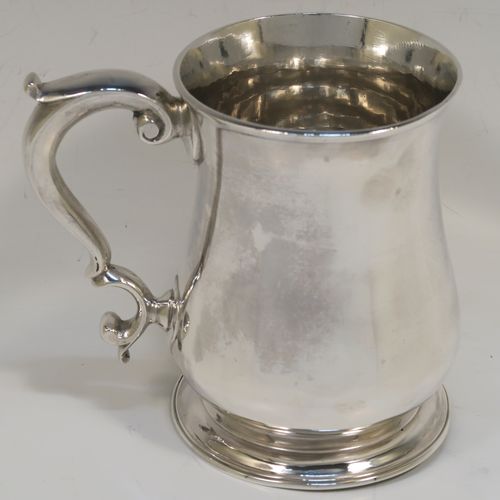 A very handsome Antique Georgian George II Sterling Silver pint tankard, having a plain round bellied body, a scroll handle with thumb-piece, and sitting on a pedestal foot. This elegant antique silver mug was made by Henry Bond of London in 1747. The dimensions of this fine hand-made antique silver pint mug or tankard are height 12 cms (4.75 inches), diameter at top 8.5 cms (3.3 inches), and it weighs approx. 441g (14 troy ounces).   