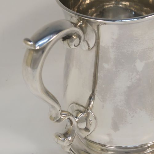 A very handsome Antique Georgian George II Sterling Silver pint tankard, having a plain round bellied body, a scroll handle with thumb-piece, and sitting on a pedestal foot. This elegant antique silver mug was made by Henry Bond of London in 1747. The dimensions of this fine hand-made antique silver pint mug or tankard are height 12 cms (4.75 inches), diameter at top 8.5 cms (3.3 inches), and it weighs approx. 441g (14 troy ounces).   