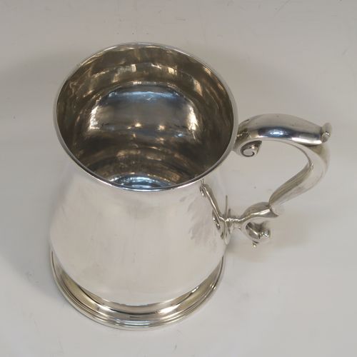 A very handsome Antique Georgian George II Sterling Silver pint tankard, having a plain round bellied body, a scroll handle with thumb-piece, and sitting on a pedestal foot. This elegant antique silver mug was made by Henry Bond of London in 1747. The dimensions of this fine hand-made antique silver pint mug or tankard are height 12 cms (4.75 inches), diameter at top 8.5 cms (3.3 inches), and it weighs approx. 441g (14 troy ounces).   