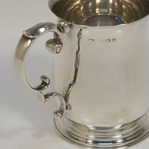 A very handsome Antique Sterling Silver half-pint tankard, having a plain round bellied body, a scroll handle with thumb-piece, and sitting on a pedestal foot. This elegant antique silver mug was made by Robert Chandler of London in 1921. The dimensions of this fine hand-made antique silver pint mug or tankard are height 10 cms (4 inches), diameter at top 7 cms (2.75 inches), and it weighs approx. 184g (5.9 troy ounces).   