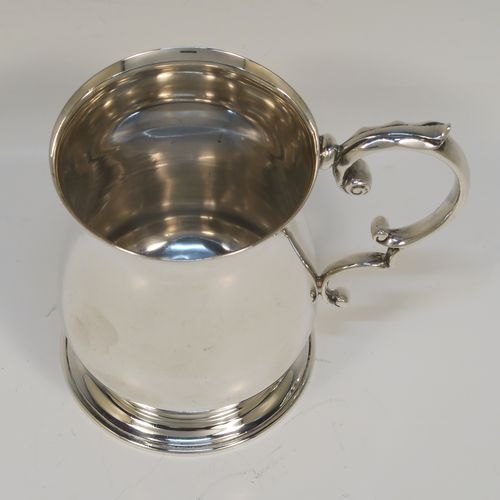 A very handsome Antique Sterling Silver half-pint tankard, having a plain round bellied body, a scroll handle with thumb-piece, and sitting on a pedestal foot. This elegant antique silver mug was made by Robert Chandler of London in 1921. The dimensions of this fine hand-made antique silver pint mug or tankard are height 10 cms (4 inches), diameter at top 7 cms (2.75 inches), and it weighs approx. 184g (5.9 troy ounces).   