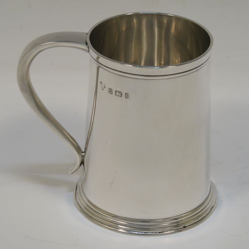 A very handsome Antique Edwardian Sterling Silver half-pint tankard, in an early George I style, having a plain round straight-sided body with tapering sides, a plain scroll side-handle, and all sitting on a collet foot. This elegant silver half-pint mug was made by Thomas Atkins of Birmingham in 1909. The dimensions of this fine hand-made silver tankard are height 9.5 cms (3.75 inches), diameter at top 6.5 cms (2.5 inches), and it weighs approx. 174g (5.6 troy ounces).   