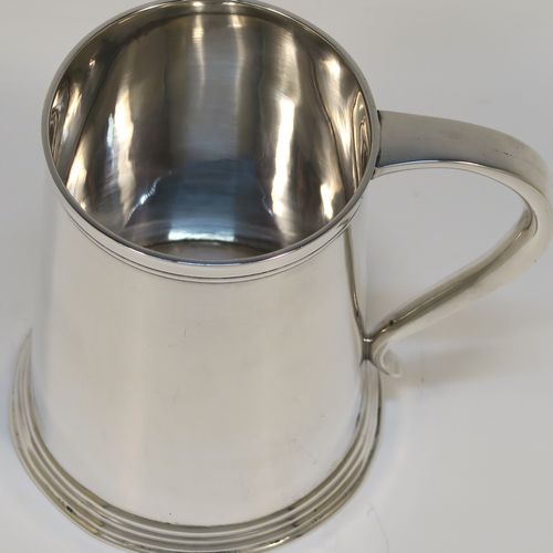 A very handsome Antique Edwardian Sterling Silver half-pint tankard, in an early George I style, having a plain round straight-sided body with tapering sides, a plain scroll side-handle, and all sitting on a collet foot. This elegant silver half-pint mug was made by Thomas Atkins of Birmingham in 1909. The dimensions of this fine hand-made silver tankard are height 9.5 cms (3.75 inches), diameter at top 6.5 cms (2.5 inches), and it weighs approx. 174g (5.6 troy ounces).   