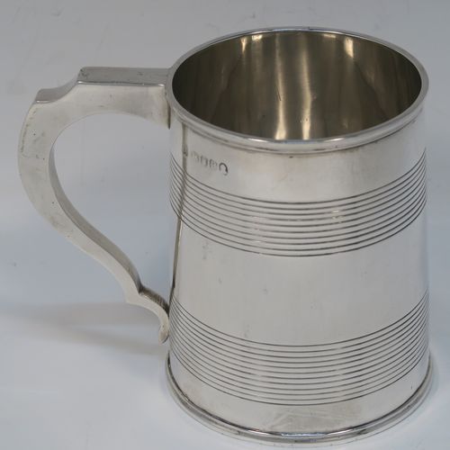 A very handsome Antique Georgian Sterling Silver pint tankard or mug, having a plain round straight-sided body with two bands of hand-chased reeded decoration and applied reeded borders, a square cross-section scroll handle, and sitting on a flat base. This elegant silver pint mug was made by Rebecca Emes and Edward Barnard I of London in 1810. The dimensions of this fine hand-made antique silver mug or tankard are height 11 cms (4.3 inches), length 13.5 cms (5.25 inches), and it weighs approx. 349g (11.25 troy ounces).   