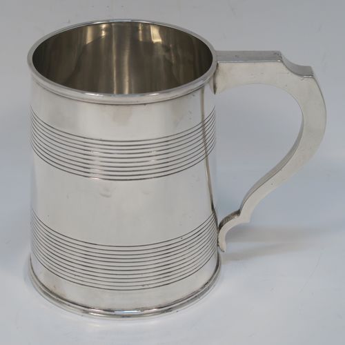 A very handsome Antique Georgian Sterling Silver pint tankard or mug, having a plain round straight-sided body with two bands of hand-chased reeded decoration and applied reeded borders, a square cross-section scroll handle, and sitting on a flat base. This elegant silver pint mug was made by Rebecca Emes and Edward Barnard I of London in 1810. The dimensions of this fine hand-made antique silver mug or tankard are height 11 cms (4.3 inches), length 13.5 cms (5.25 inches), and it weighs approx. 349g (11.25 troy ounces).   