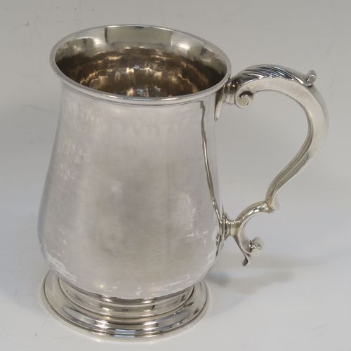 A very handsome Antique Georgian George III Sterling Silver half-pint tankard, having a plain round bellied body, a scroll handle with Anthemion leaf thumb-piece, and sitting on a pedestal foot. This elegant silver half-pint mug was made by Thomas Wallis I of London in 1779. The dimensions of this fine hand-made antique silver half-pint mug or tankard are height 10 cms (4 inches), diameter at top 7 cms (2.75 inches), and it weighs approx. 199g (6.4 troy ounces).   