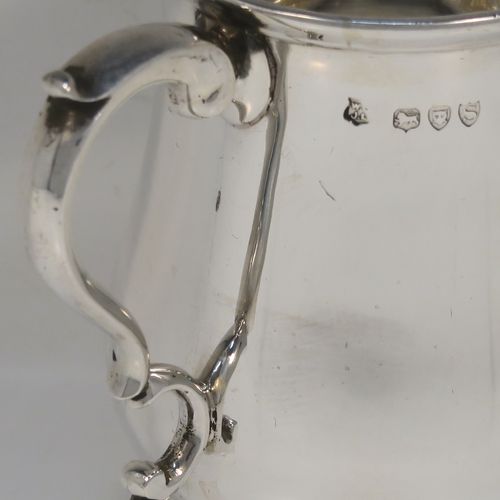 A very handsome Antique Victorian Sterling Silver half-pint tankard, having a plain round bellied body, a scroll handle with thumb-piece, and sitting on a pedestal foot. This elegant antique silver mug was made by Gibson and Langland of London in 1893. The dimensions of this fine hand-made antique silver pint mug or tankard are height 10 cms (4 inches), diameter at top 7 cms (2.75 inches), and it weighs approx. 191g (6.2 troy ounces).  