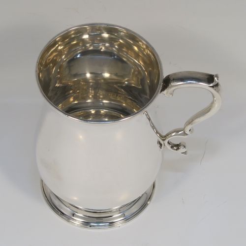 A very handsome Antique Victorian Sterling Silver half-pint tankard, having a plain round bellied body, a scroll handle with thumb-piece, and sitting on a pedestal foot. This elegant antique silver mug was made by Gibson and Langland of London in 1893. The dimensions of this fine hand-made antique silver pint mug or tankard are height 10 cms (4 inches), diameter at top 7 cms (2.75 inches), and it weighs approx. 191g (6.2 troy ounces).  