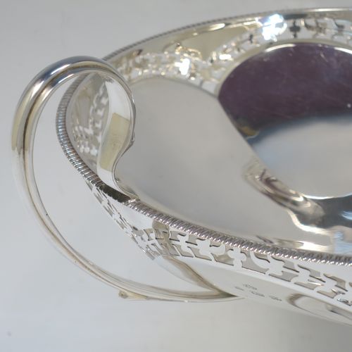 A very pretty Sterling Silver tazza dish, having a round body with an applied gadroon border above a lobed band of hand-pierced floral decoration, with two scroll side-handles, and all sitting on a matching pedestal foot. Made by Elkington and Co., of Birmingham in 1920. The dimensions of this fine hand-made silver tazza dish are height 18.5 cms (7.3 inches), diameter 21 cms (8.25 inches), and it weighs approx. 615g (19.8 troy ounces).   