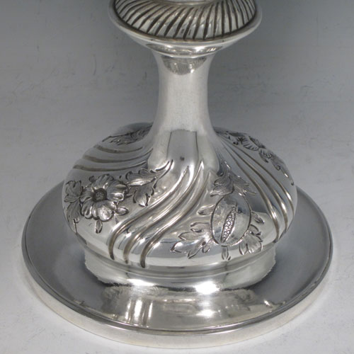 Antique Victorian sterling silver tazza dish, having a round body with hand-chased floral and fruit decoration, sitting on a pedestal foot with matching decoration and swirl fluting. Made by Henry Holland of London in 1874. The dimensions of this fine hand-made silver tazza dish are height 21 cms (8.25 inches), diameter 26 cms (10.25 inches), and it weighs approx. 838g (27 troy ounces).