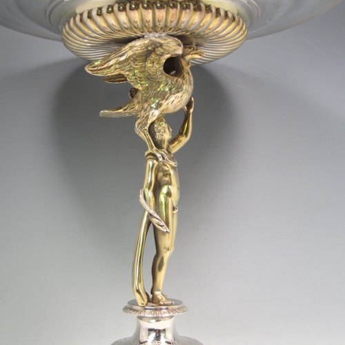 Antique Victorian sterling silver tazza dish and cover, having a round body with half-fluted chasing and an applied gadroon border, held up by a cast gold-gilt model of Zeus with his emblem of an eagle, and sitting on a pedestal foot with hand-engraved floral decoration, together with a lift off lid with a cast model of Veritas and Globe as a finial. Made by Alexander Macrae of London in 1868. The dimensions of this fine hand-made silver tazza dish are height 42 cms (16.5 inches), diameter 28 cms (11 inches), and it weighs approx. 1,954g (63 troy ounces).