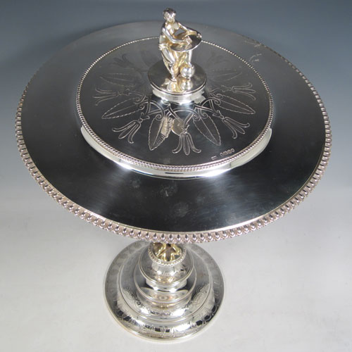 Antique Victorian sterling silver tazza dish and cover, having a round body with half-fluted chasing and an applied gadroon border, held up by a cast gold-gilt model of Zeus with his emblem of an eagle, and sitting on a pedestal foot with hand-engraved floral decoration, together with a lift off lid with a cast model of Veritas and Globe as a finial. Made by Alexander Macrae of London in 1868. The dimensions of this fine hand-made silver tazza dish are height 42 cms (16.5 inches), diameter 28 cms (11 inches), and it weighs approx. 1,954g (63 troy ounces).