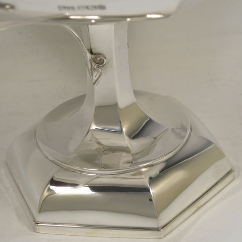 A very handsome Sterling Silver tazza dish or bowl, having a plain hexagonal paneled body, with two cast side-handles having scroll-leaf terminals, and sitting on a matching pedestal foot. This beautiful tazza dish was made by Walker and Hall of Sheffield in 1927. The dimensions of this fine hand-made silver tazza bowl or dish are height 16 cms (6.3 inches), width across handles 31 cms (12.25 inches), and it weighs approx. 638g (20.6 troy ounces).   