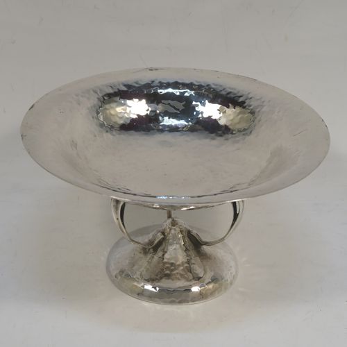 A very handsome Antique Edwardian Sterling Silver Arts and Crafts style tazza dish, having a round bowl attached to a pedestal foot with three scroll arms, and an all-over hand-hammered or plenished finish. This beautiful silver tazza dish was made by Walker and Hall of Sheffield in 1909. The dimensions of this fine hand-made antique silver dish are height 9 cms (3.5 inches), diameter 16 cms (6.3 inches), and it weighs approx. 203g (6.5 troy ounces).   