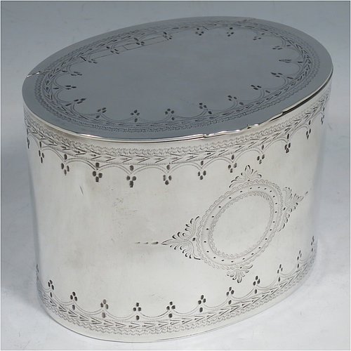 An Antique Victorian Silver Plated tea caddy box, having an oval straight-sided body, a flat lid with a hidden hinge, with hand-engraved bands of floral decoration top and bottom, together with two round  cartouches front and back, and sitting on a flat base. Made by the Mappin Brothers in ca. 1870. The dimensions of this fine hand-made antique silver-plated tea caddy box are height 9 cms (3.5 inches), length 12 cms (4.75 inches), and width 9 cms (3.5 inches).