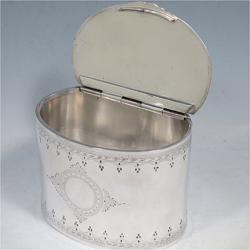 An Antique Victorian Silver Plated tea caddy box, having an oval straight-sided body, a flat lid with a hidden hinge, with hand-engraved bands of floral decoration top and bottom, together with two round  cartouches front and back, and sitting on a flat base. Made by the Mappin Brothers in ca. 1870. The dimensions of this fine hand-made antique silver-plated tea caddy box are height 9 cms (3.5 inches), length 12 cms (4.75 inches), and width 9 cms (3.5 inches).